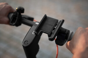 Présentation du support installé sur une trottinette Ninebot, illustrant l’accessibilité des commandes et l’intégration discrète.
