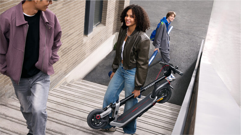 Utilisatrice montant un escalier en portant sa Ninebot E3 E – mobilité urbaine