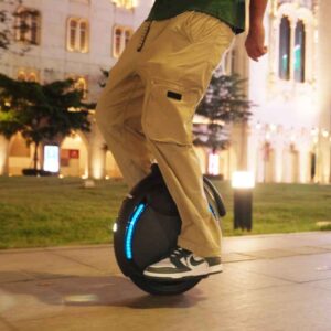 Personne roulant sur l’INMOTION V6 de nuit en environnement urbain éclairé.