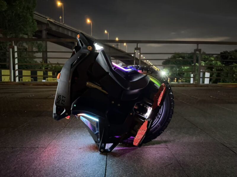 Custom led pour Gyroroue Nosfet Aero 3 Gyroroue Nosfet Aero noire avec éclairages LED colorés, photographiée de nuit en milieu urbain.