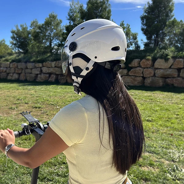 CASQUE URBAN MOOV VISOR 12 Casque Urban Moov Visor blanc vu de dos, porté en extérieur sur une trottinette électrique